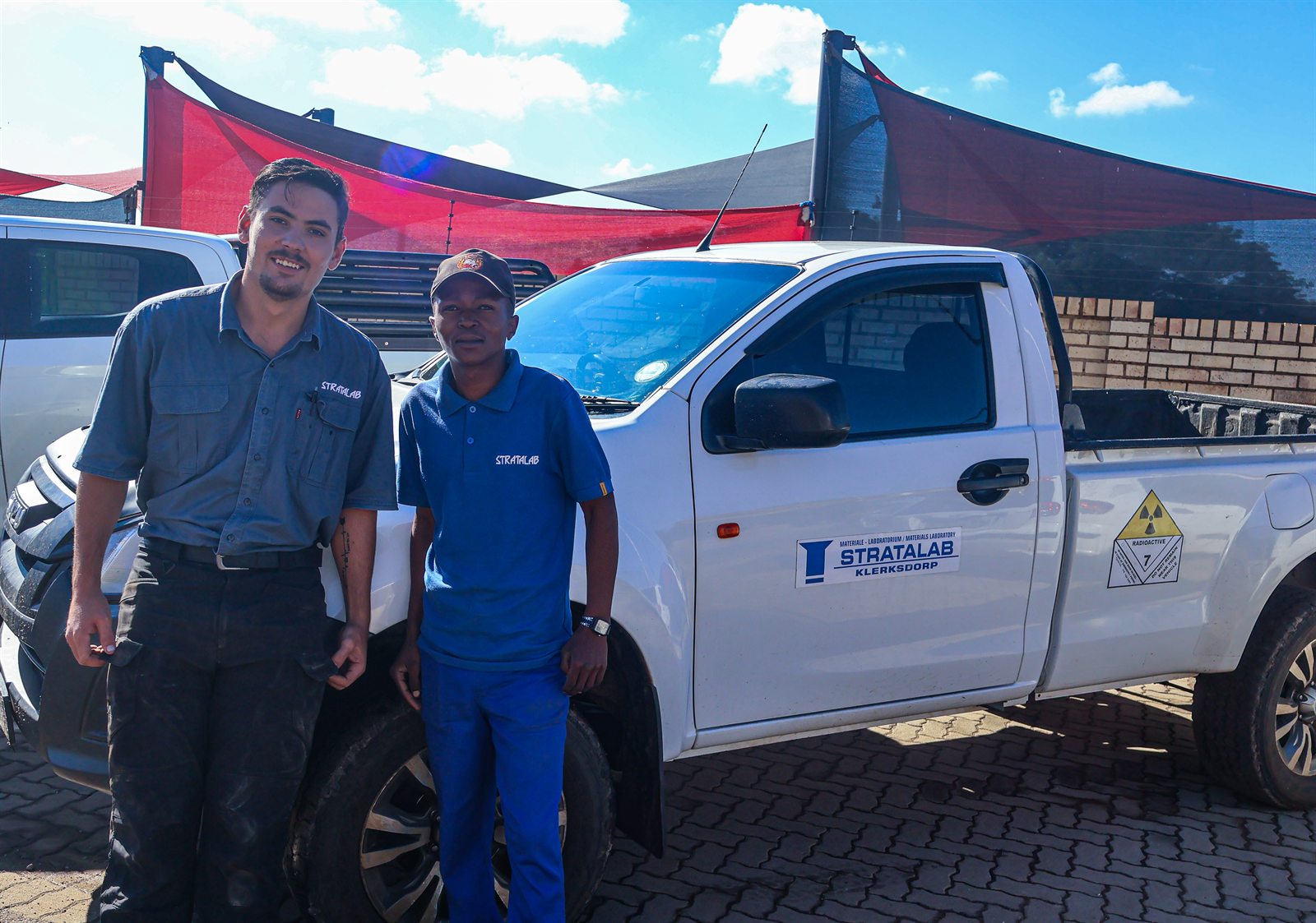 Stratalab team members beside a branded vehicle