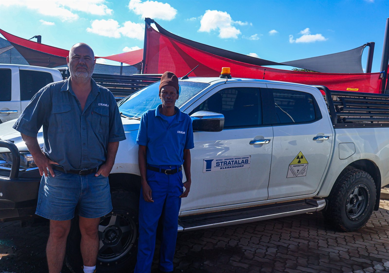 Stratalab team members standing beside a field vehicle