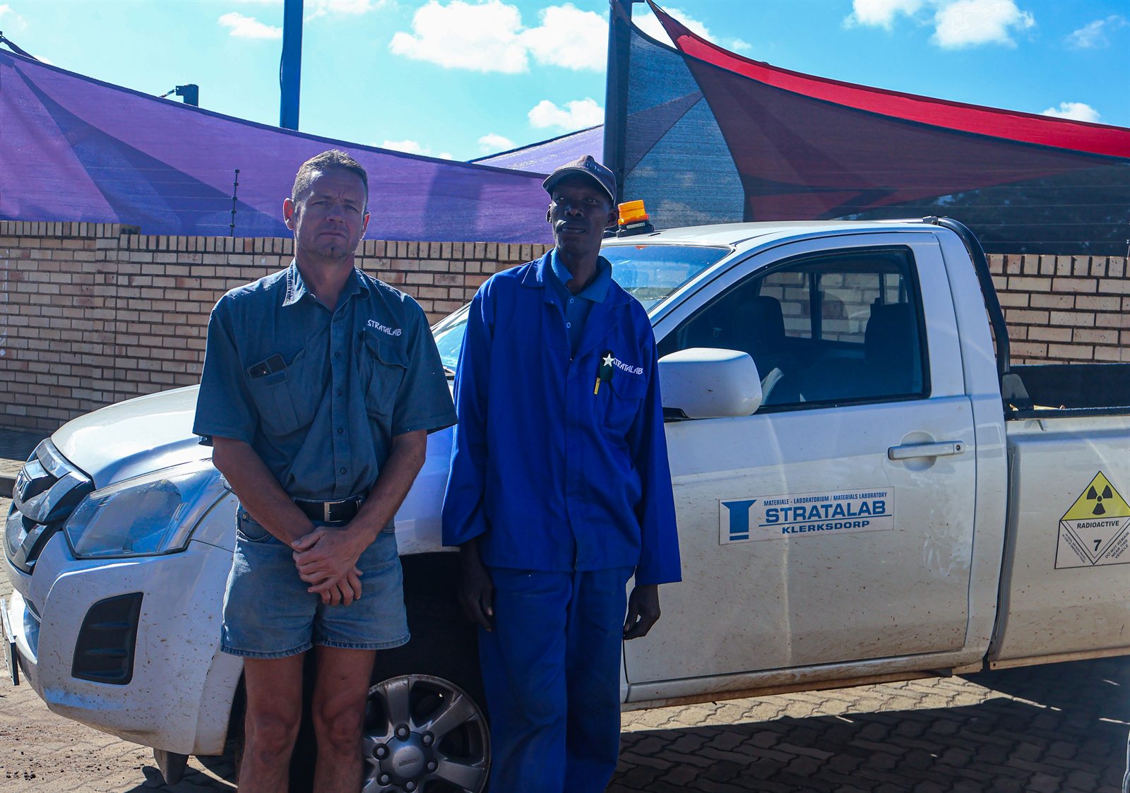 Stratalab staff members posing beside a site vehicle