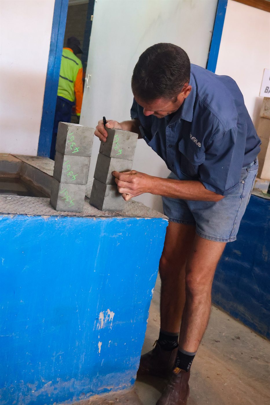 Technician marking concrete test cubes