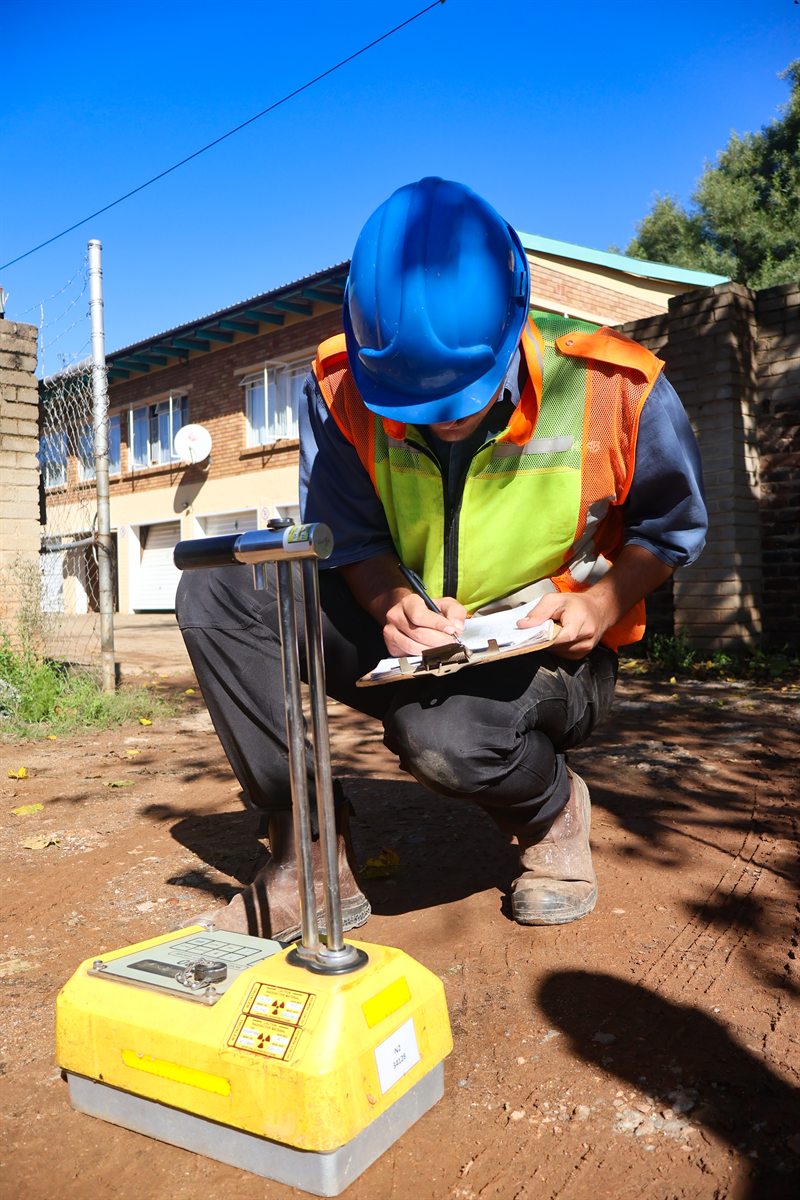 Technician recording compaction testing results on site
